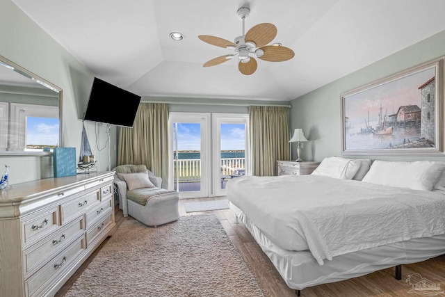 bedroom featuring a raised ceiling, dark wood-type flooring, access to exterior, and ceiling fan