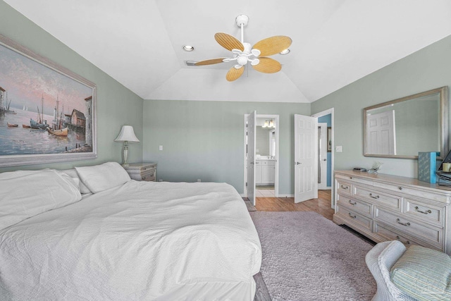 bedroom featuring ceiling fan, lofted ceiling, ensuite bathroom, and light wood-type flooring