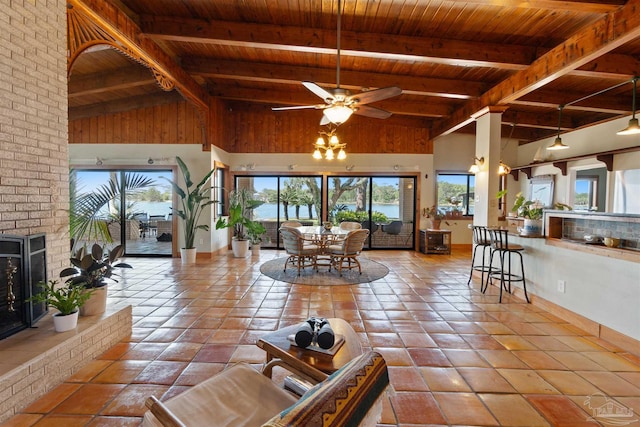 living room featuring a brick fireplace, beamed ceiling, high vaulted ceiling, ceiling fan, and wooden ceiling