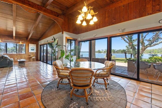 dining area featuring a water view, light tile patterned floors, wood ceiling, and beamed ceiling