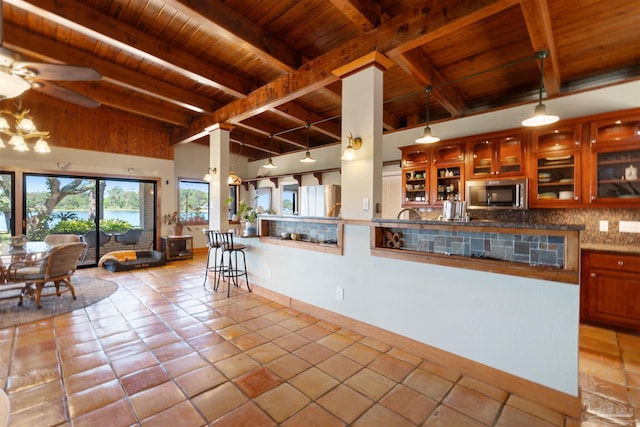 kitchen featuring hanging light fixtures, beam ceiling, wood ceiling, and rail lighting