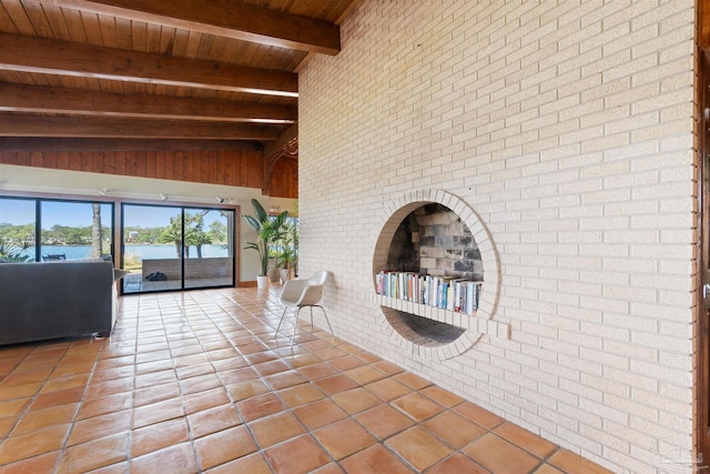 unfurnished living room featuring beam ceiling, tile patterned flooring, wood ceiling, and brick wall