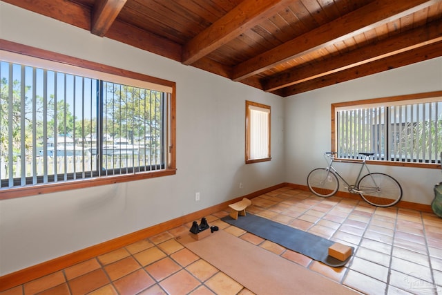 tiled empty room with plenty of natural light, wood ceiling, and vaulted ceiling with beams