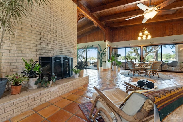 tiled living room with ceiling fan with notable chandelier, wood ceiling, a fireplace, high vaulted ceiling, and beam ceiling