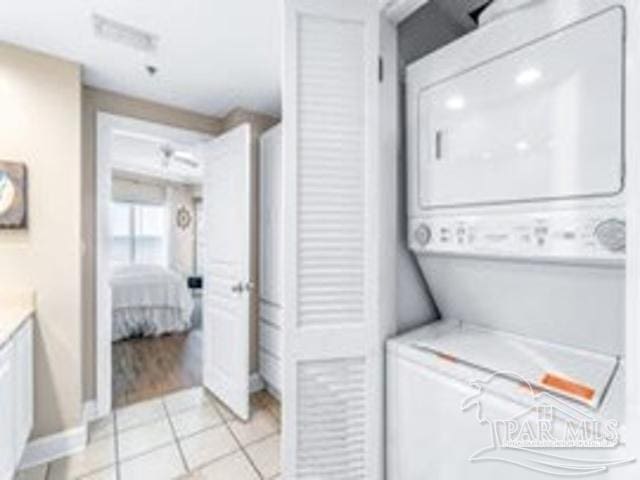 22984 Perdido Beach Blvd Unit B42, Orange Beach, AL 36561 - laundry room featuring stacked washing maching and dryer and light tile patterned floors