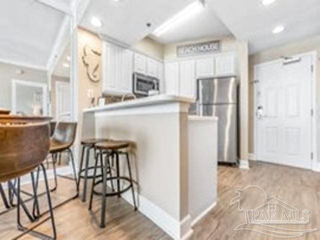 22984 Perdido Beach Blvd Unit B42, Orange Beach, AL 36561 - kitchen with recessed lighting, light wood-style floors, a peninsula, appliances with stainless steel finishes, and white cabinetry