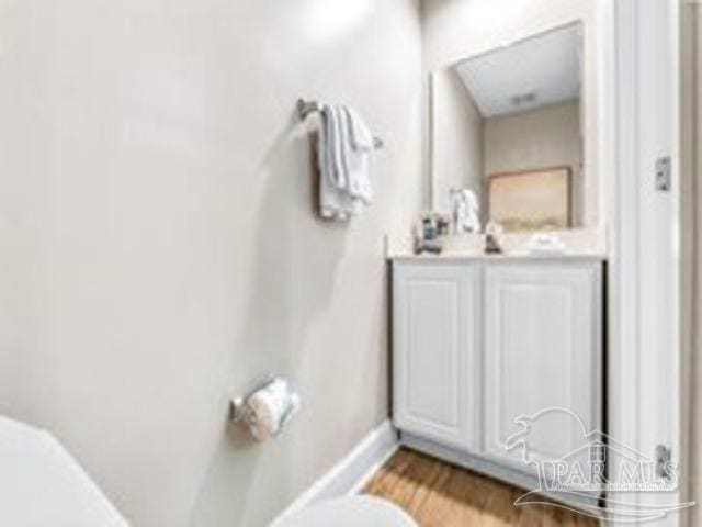22984 Perdido Beach Blvd Unit B42, Orange Beach, AL 36561 - bathroom with baseboards, wood finished floors, toilet, and vanity