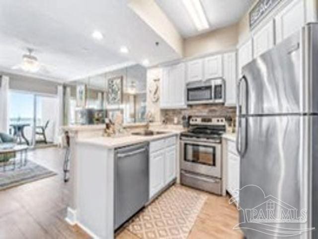 22984 Perdido Beach Blvd Unit B42, Orange Beach, AL 36561 - kitchen with a peninsula, tasteful backsplash, appliances with stainless steel finishes, and white cabinets
