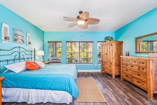 bedroom with a textured ceiling, ceiling fan, and dark hardwood / wood-style floors