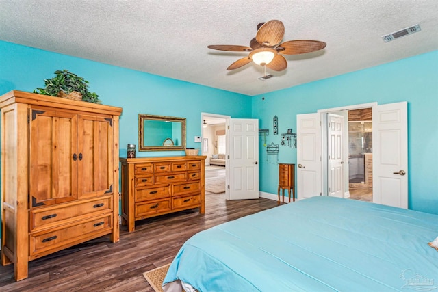 bedroom with ceiling fan, dark hardwood / wood-style flooring, ensuite bathroom, and a textured ceiling