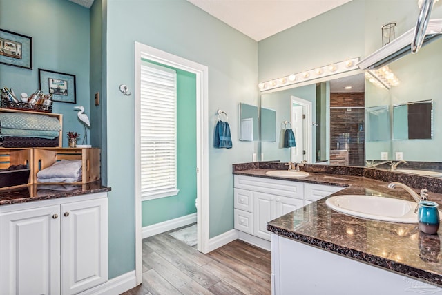 bathroom featuring hardwood / wood-style floors, vanity, toilet, and a shower with shower door