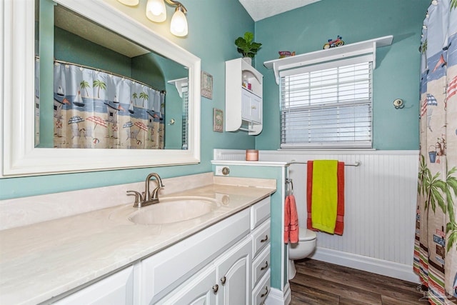 bathroom featuring vanity, a textured ceiling, hardwood / wood-style flooring, and toilet