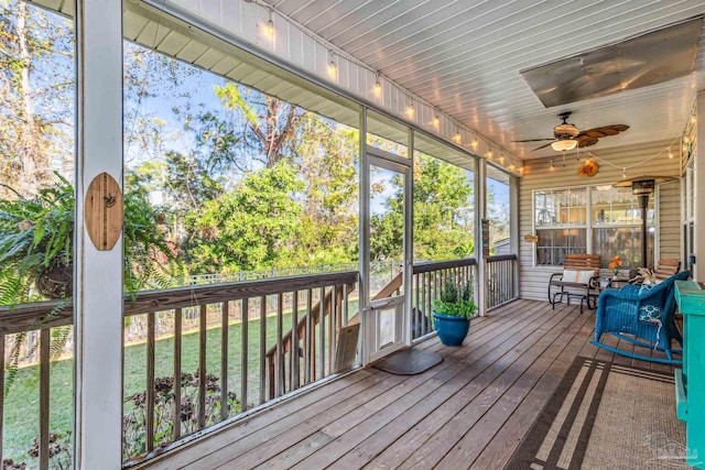 unfurnished sunroom with ceiling fan