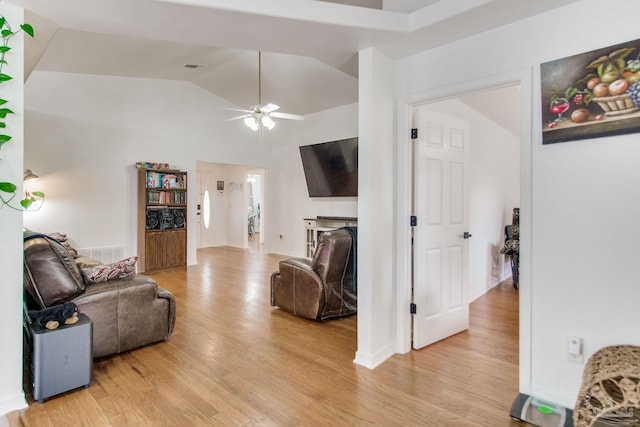 living room with visible vents, a ceiling fan, light wood-style floors, and lofted ceiling