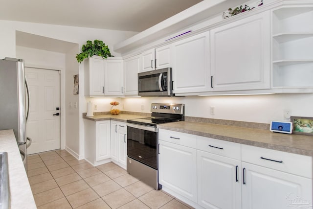 kitchen with light tile patterned flooring, white cabinets, open shelves, and stainless steel appliances