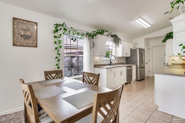dining room featuring light tile patterned flooring, visible vents, and vaulted ceiling