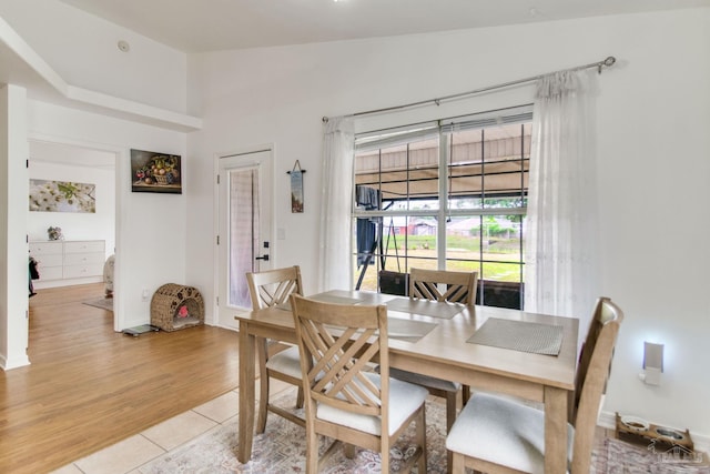 dining area with light tile patterned floors and vaulted ceiling