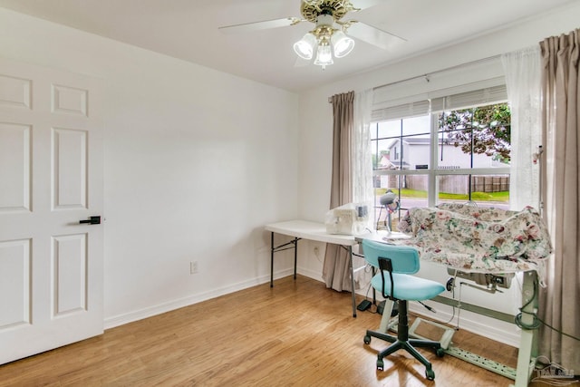 office space featuring ceiling fan, light wood finished floors, and baseboards