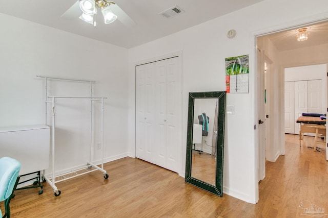 interior space with visible vents, ceiling fan, light wood-style floors, and a closet