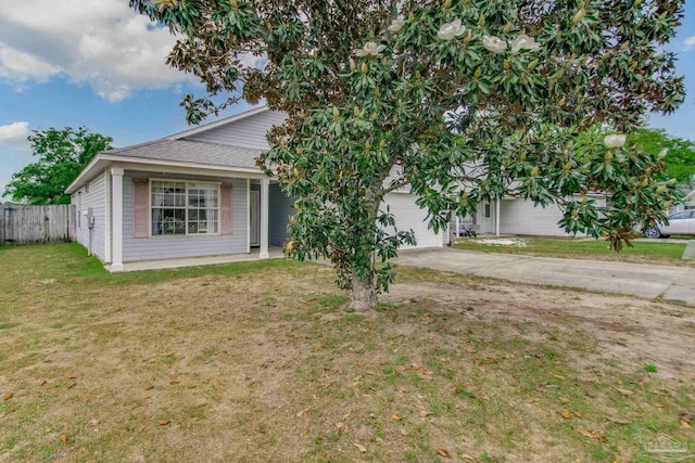 obstructed view of property with a front lawn, a garage, driveway, roof with shingles, and fence