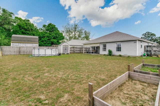 view of yard with an outbuilding, a storage shed, a garden, and a fenced backyard