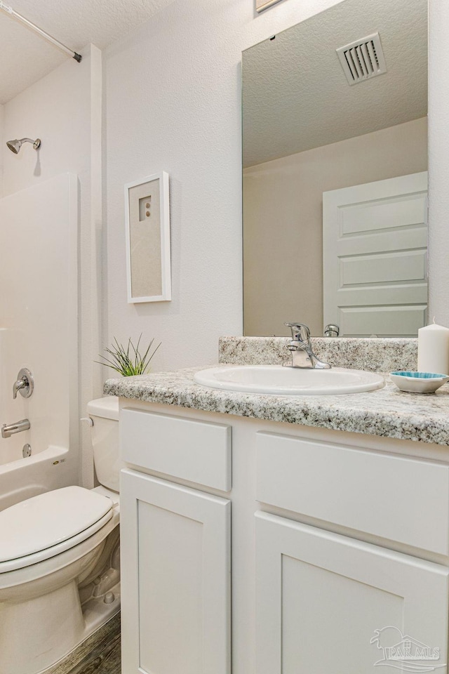 full bathroom featuring shower / bath combination, vanity, a textured ceiling, hardwood / wood-style floors, and toilet