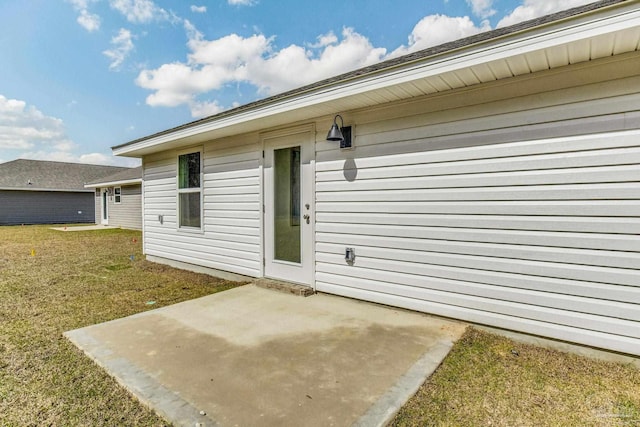 entrance to property with a patio area and a yard