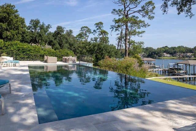 view of swimming pool featuring a patio and a water view