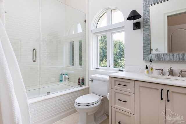 full bathroom with shower / bath combination with glass door, tile patterned floors, vanity, and toilet