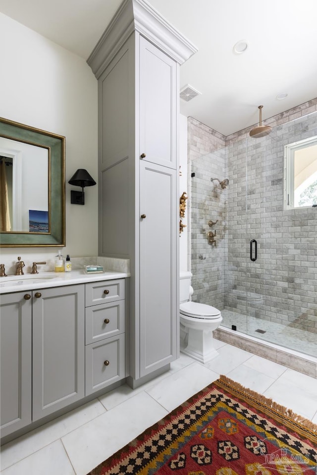 bathroom featuring tile patterned flooring, vanity, toilet, and a shower with door