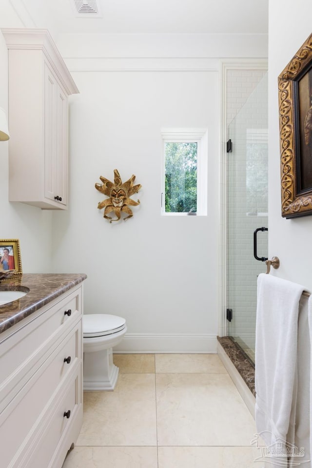 bathroom featuring tile patterned floors, vanity, toilet, and an enclosed shower