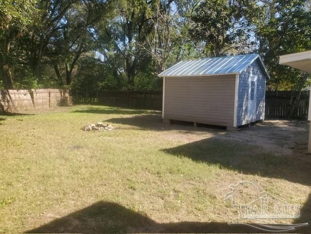 view of yard featuring a storage unit, an outdoor structure, and a fenced backyard