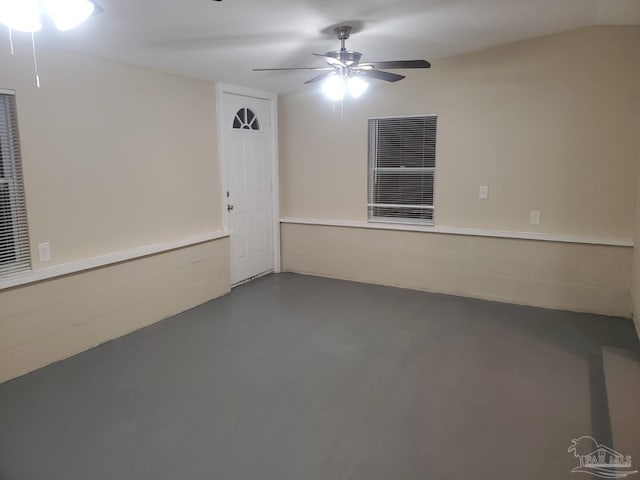 spare room with a ceiling fan and concrete floors