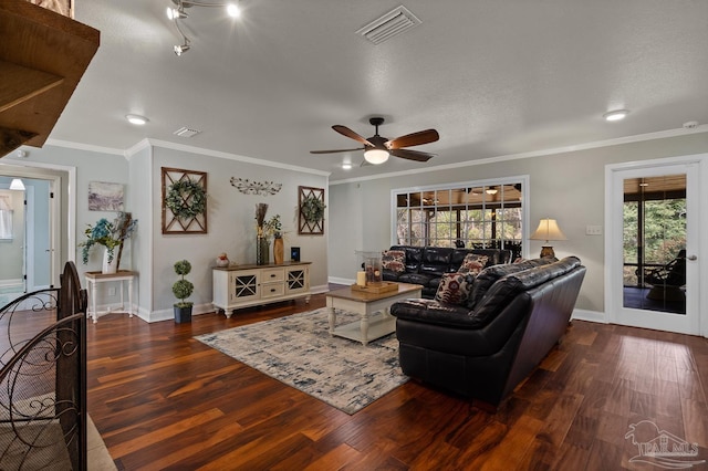 living room with dark wood-type flooring, ceiling fan, ornamental molding, and a textured ceiling