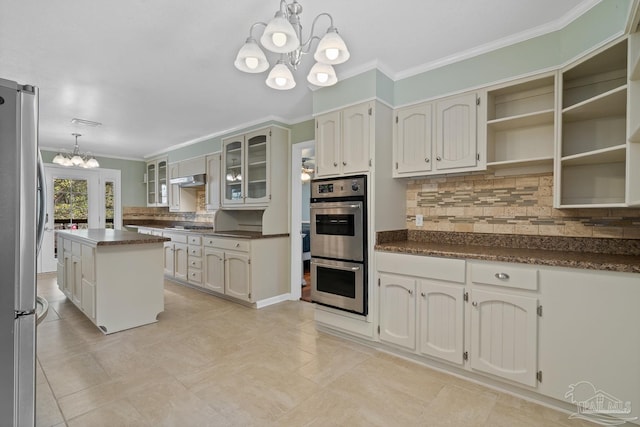 kitchen featuring pendant lighting, white cabinetry, stainless steel appliances, a center island, and a chandelier