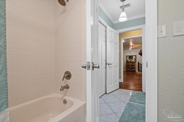 bathroom with ornamental molding, shower / bathtub combination with curtain, and tile patterned floors