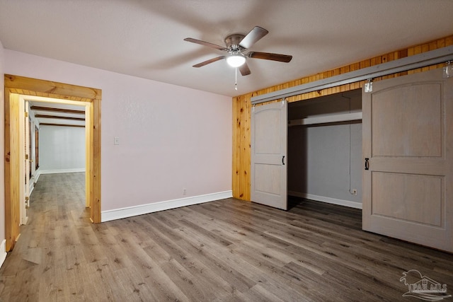 unfurnished bedroom with hardwood / wood-style flooring, a closet, and ceiling fan