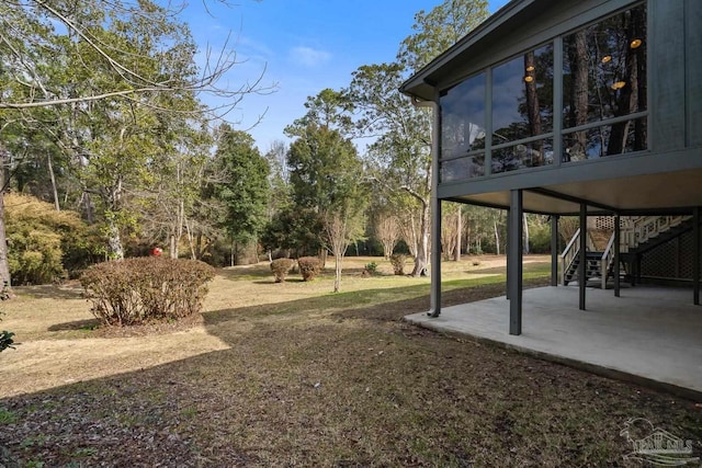 view of yard featuring a sunroom and a patio area