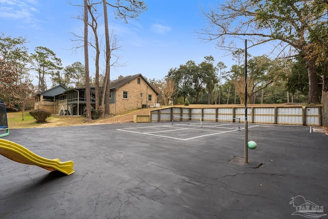 view of vehicle parking featuring tennis court