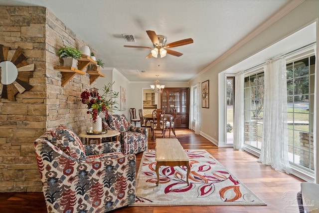 living room with crown molding, ceiling fan with notable chandelier, and hardwood / wood-style floors