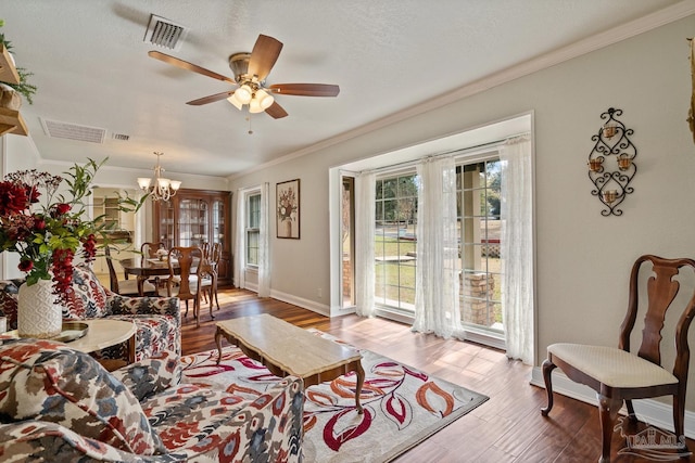 living room with crown molding, wood-type flooring, ceiling fan with notable chandelier, and a textured ceiling