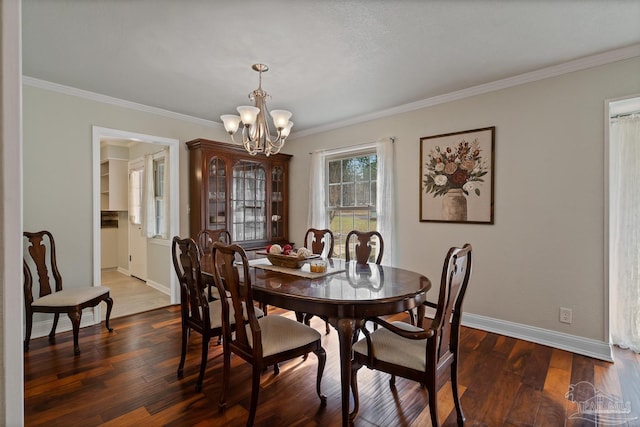 dining room with a notable chandelier, dark wood-type flooring, and ornamental molding