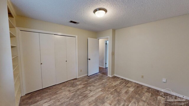 empty room featuring ceiling fan, hardwood / wood-style floors, and a textured ceiling