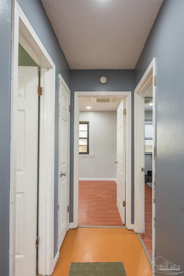 2322 Silversides Loop, Pensacola, FL 32526 - hall with wood finished floors, baseboards, healthy amount of natural light, and a textured ceiling