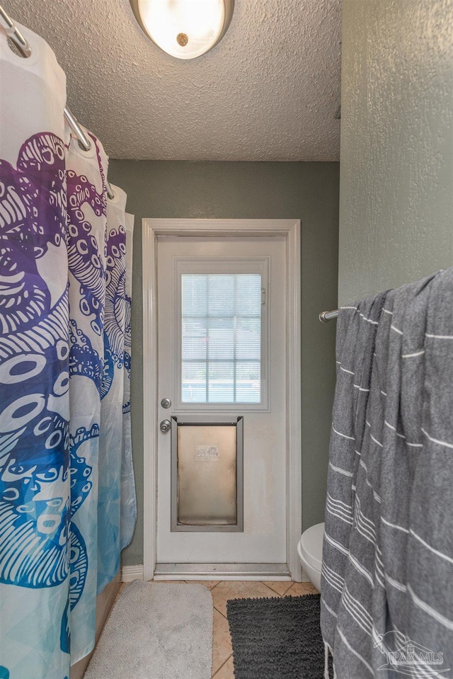 2322 Silversides Loop, Pensacola, FL 32526 - bathroom featuring tile patterned floors, toilet, a textured ceiling, and a shower with shower curtain