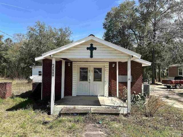 view of front facade with cooling unit and covered porch