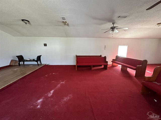 interior space featuring ceiling fan, a textured ceiling, and carpet flooring