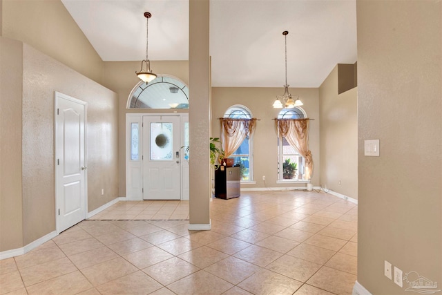 tiled foyer entrance with lofted ceiling and an inviting chandelier