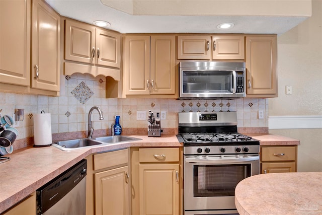 kitchen with light brown cabinetry, sink, appliances with stainless steel finishes, and tasteful backsplash