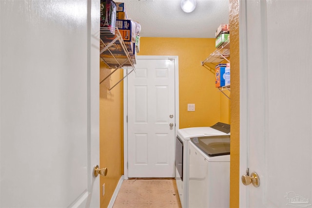 washroom featuring a textured ceiling and separate washer and dryer